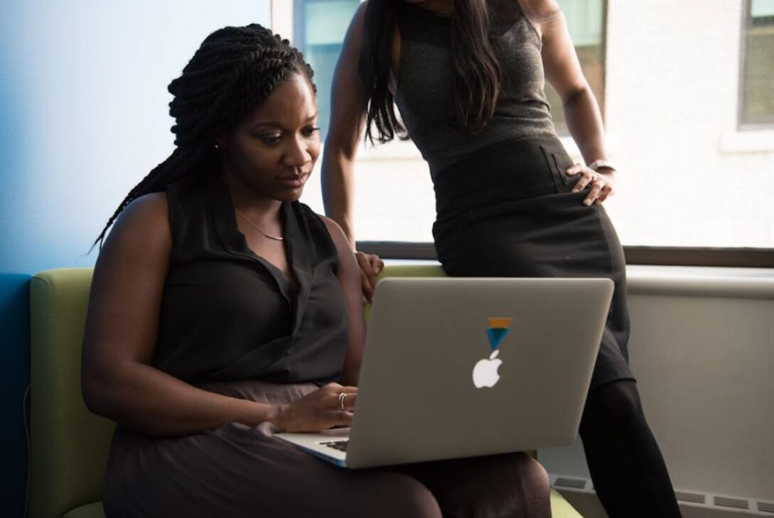 A female professional explaining 'What is contact center solutions_' to her colleague using a presentation or visual aids.