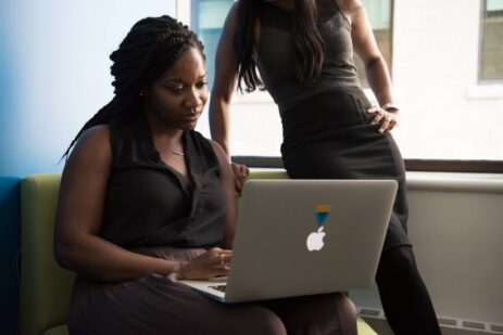 A female professional explaining 'What is contact center solutions_' to her colleague using a presentation or visual aids.