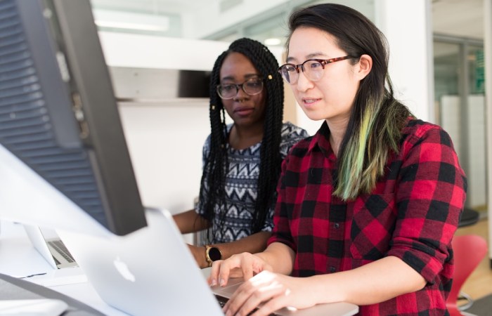 Two employees collaborating on strategies for leveraging contact centers to boost customer loyalty, focusing on best practices and innovative solutions.